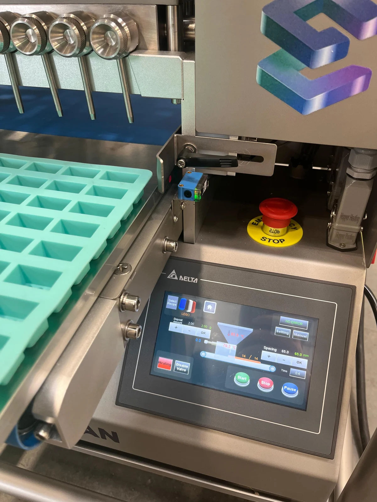 Silicone mold positioned under the tabletop depositor nozzles, beside its touchscreen
